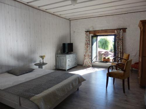 1 dormitorio con 1 cama, TV y ventana en La Grange de Bois de Chêne, en Phalsbourg