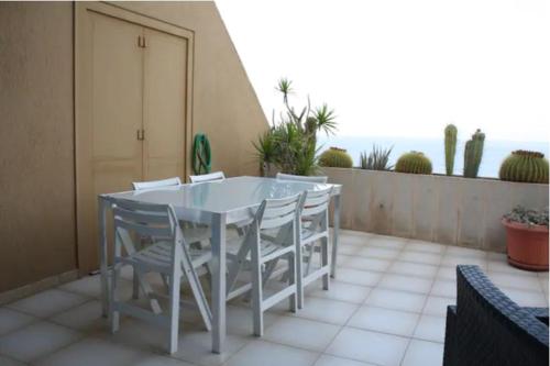 un tavolo bianco e sedie su un balcone con vista sull'oceano di Apartamento frente al mar a Radazul