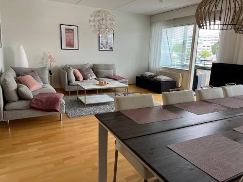 a living room with a table and a couch at Tasokas jokiranta-asunto lähellä ydinkeskustaa in Turku