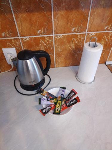 a tea kettle and a plate with packets of candy at Cezar in Arandjelovac