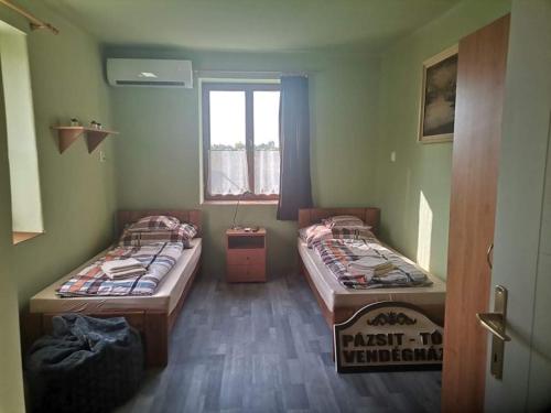 Habitación con 2 camas y ventana en Pázsit-tó Vendégház, en Békésszentandrás