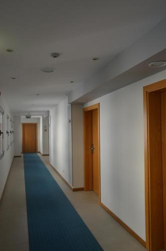 an empty hallway with a blue carpet in a building at Madeira Bright Star by Petit Hotels in Funchal