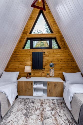a room with two beds and a window and a tv at Luxury Cottages with Hot Tubes, Garden and BBQ in Mtskheta