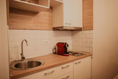 una cucina con lavandino e un apparecchio rosso su un bancone di Apartman Neo a Mostar