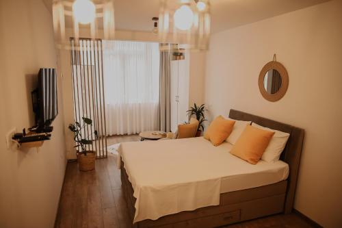 ein Schlafzimmer mit einem Bett mit orangefarbenen Kissen in der Unterkunft Apartman Neo in Mostar