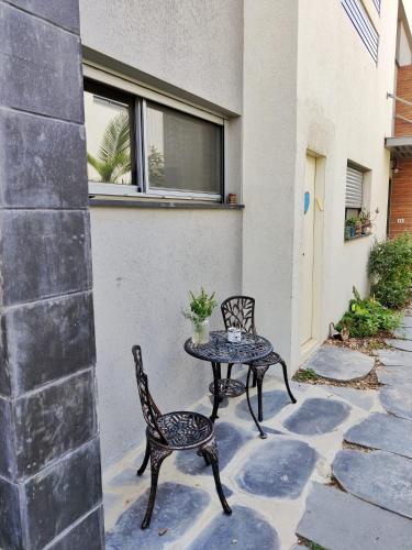 a patio with two chairs and a table at נקודות ריפוי in Tirat Karmel