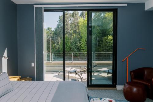 a bedroom with a bed and a sliding glass door at THE NEST: Luxury, History, Balcony, Memories in Traverse City