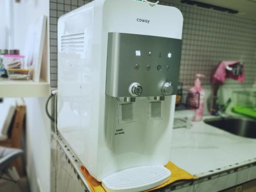 a white appliance sitting on top of a kitchen counter at Aishiteru Homestay in Kuala Lumpur