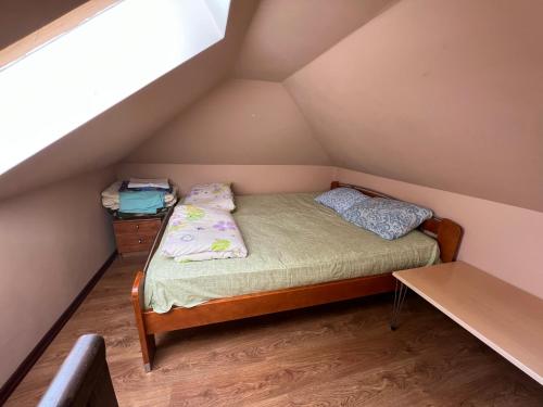 um pequeno quarto com uma cama no sótão em Ragaciems Guest house Beach 5 min Viesu māja pie jūras Апартаменты у моря em Ragaciems
