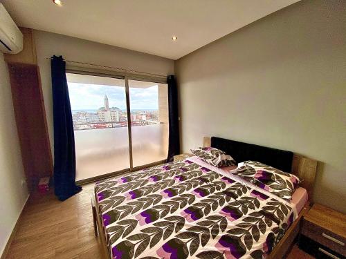 a bedroom with a bed and a large window at Anfa 118 - Best view in town. 3 bedrooms. 2 bathrooms. Great location. in Casablanca