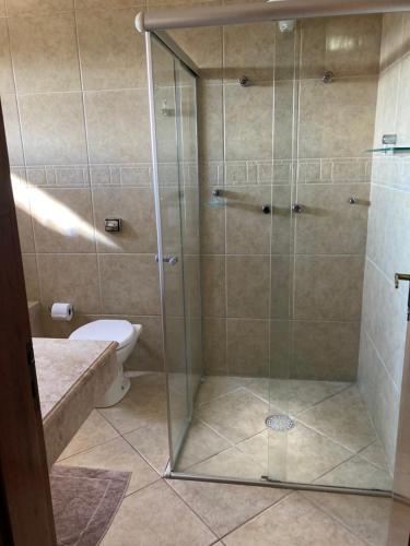 ein Badezimmer mit Glasdusche und Toilette in der Unterkunft sonho de valsa in Campos do Jordão