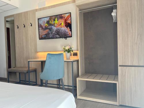 a bedroom with a bed and a desk and a chair at Hotel Gardenia in Romano Canavese