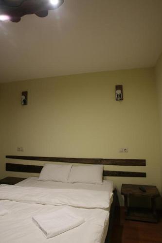 a bedroom with a white bed and a table at Cheremosh in Yablunytsya