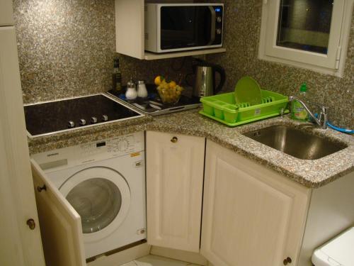 a kitchen with a sink and a washing machine at Apartment on the Croisette with sea view in Cannes