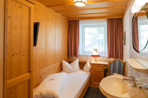 a room with a bed and a sink in a room at Landhaus Marion in Holzgau