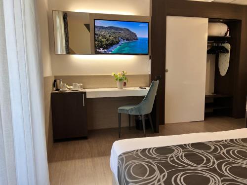 a hotel room with a bed and a desk and a mirror at Hotel Gardenia in Romano Canavese
