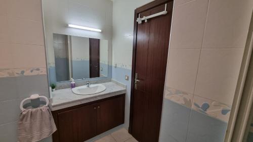 uma casa de banho com um lavatório e um espelho em My Cosy Place Rabat - Skhirat 2min de la plage avec Piscine em Skhirat