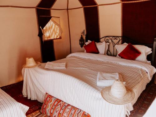 um quarto com duas camas com chapéus em Deep Desert Camp em Merzouga