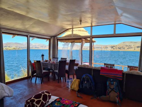 a dining room with a view of the water at TITICACA JALTAWI LODGE in Puno