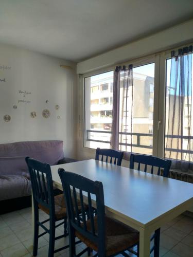 un salon avec une table, des chaises et un canapé dans l'établissement Appartement F2 à 50 m de la plage, à Nice