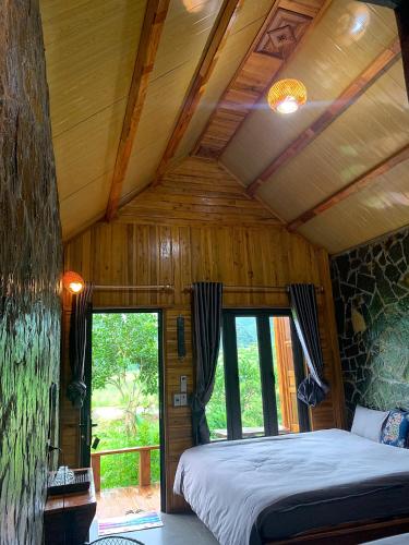 a bedroom with a bed in a room with windows at mai chau rice fields homestay in Mai Châu