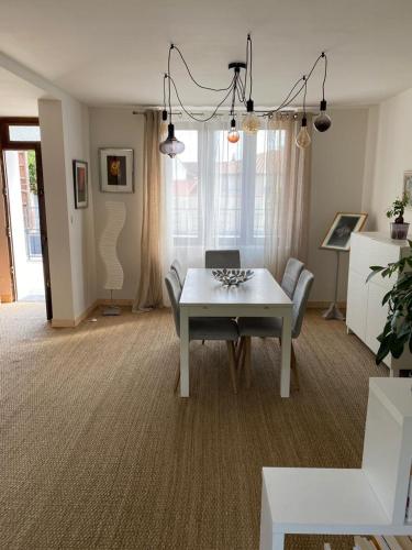 un salon avec une table blanche et un canapé dans l'établissement Villa au calme dans un écrin de verdure 3ch, à Aytré