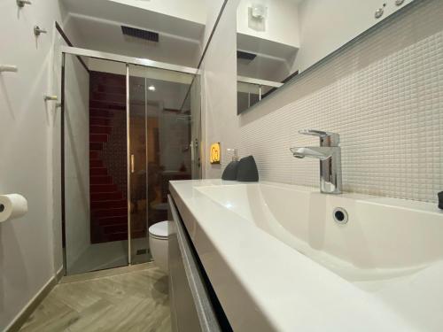 a white bathroom with a sink and a toilet at MarEtna in Giardini Naxos