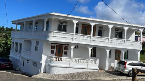a white house with a car parked in front of it at The Golden Inn in Marigot