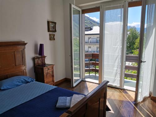 a bedroom with a bed and sliding glass doors at La Casa Del Quirino in Tirano