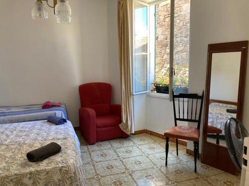 1 dormitorio con 1 cama, 1 silla y 1 ventana en Plan B, en Civezza