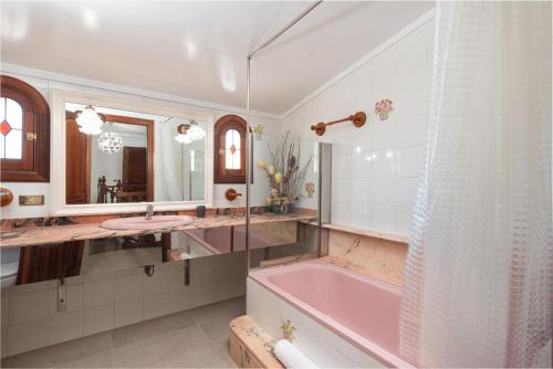 a bathroom with a pink tub and a sink at Villa Roses - Alcúdia in Alcudia