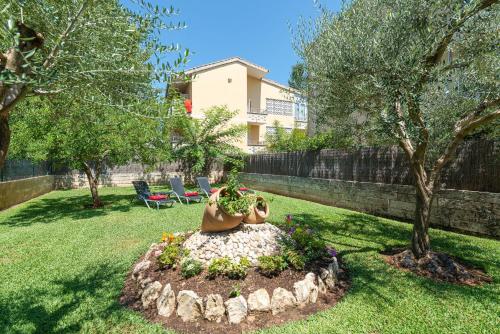 a garden with a statue in the grass at Villa Roses - Alcúdia in Alcudia