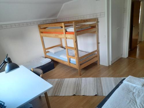 Cette chambre comprend 2 lits superposés et une table. dans l'établissement House next door the Arctic Circle, à Överkalix