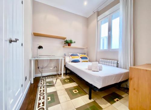 1 dormitorio con cama, escritorio y ventana en Charming Blasco de Garay - Estancias Temporales, en Madrid