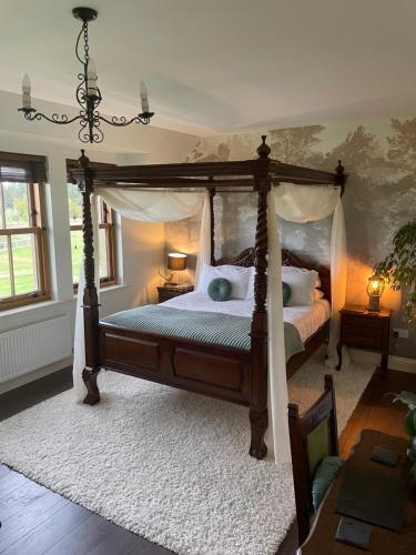 a bedroom with a canopy bed with white pillows at Ach-Na-Sidhe in Dores