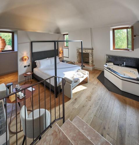 a bedroom with a bed and a tub in a room at RELAIS CASCINA ERA in Sandigliano