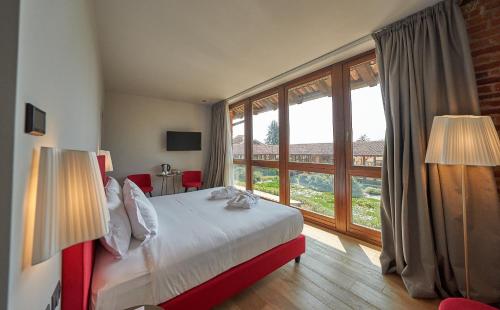 a bedroom with a bed and a large window at RELAIS CASCINA ERA in Sandigliano