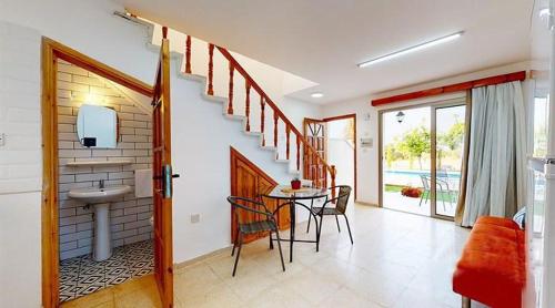 a living room with a sink and a table with chairs at Templos Homes in Kérynia