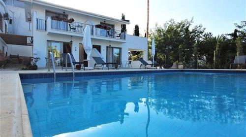 a large blue swimming pool in front of a house at Templos Homes in Kérynia