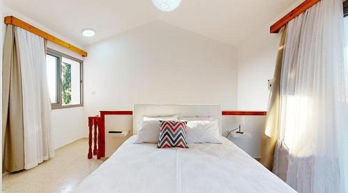 a bedroom with a white bed and a window at Templos Homes in Kérynia