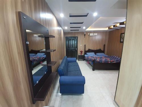 a hotel room with two beds and a mirror at Heaven Heights Apartment in Murree