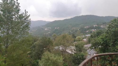 a view of a valley with trees and mountains at Heaven Heights Apartment in Murree