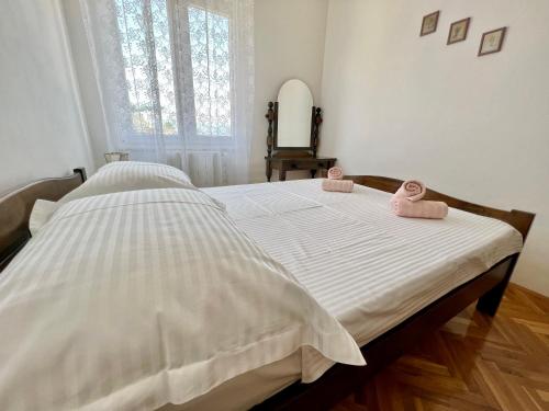 a bedroom with a bed with two pink towels on it at Villa Slatine apartment in Slatine