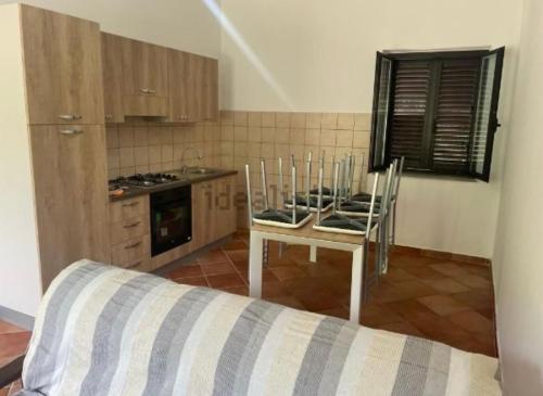 uma cozinha com mesa e cadeiras num quarto em Villa Caterina em Ioppolo