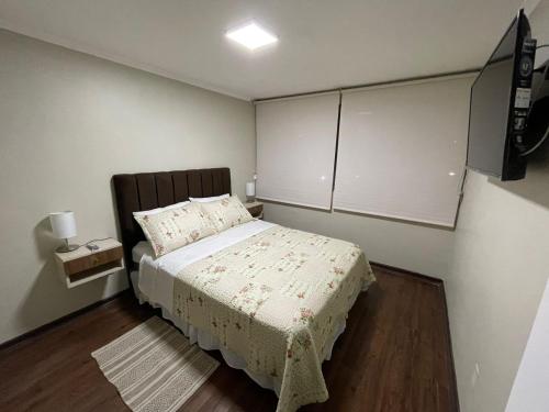 a small bedroom with a bed and a tv at M-Montt Providencia Apartamentos Amoblados in Santiago