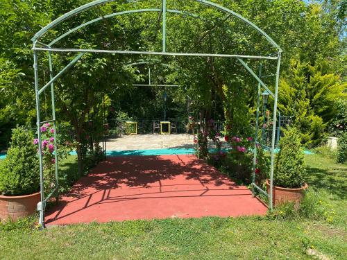 a metal archway with a red path in a garden at Sarikonaklar Garden Village in Şile
