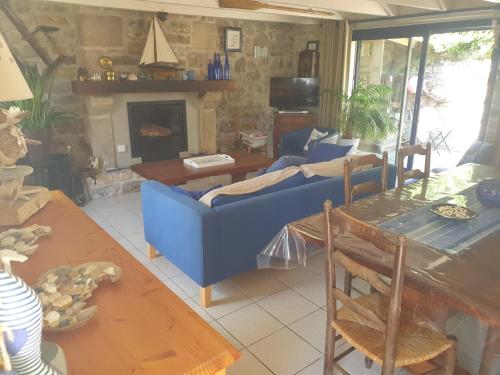 un salon avec un canapé bleu et une cheminée dans l'établissement Maison typique bretonne a 5 min de la plage a pied, à Crozon