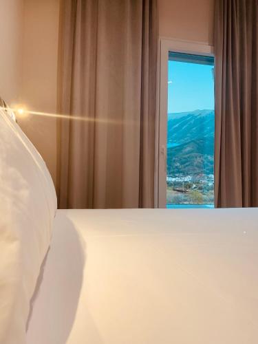 a bedroom with a white bed and a window at Merly Hotel in Përmet