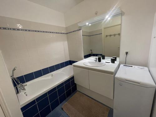 a bathroom with a sink and a toilet and a tub at Superbe T2 avec parking et loggia in Marseille