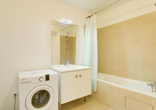 une salle de bain avec une machine à laver et un lavabo dans l'établissement Au CALME entre DISNEY et PARIS, à Villiers-sur-Marne